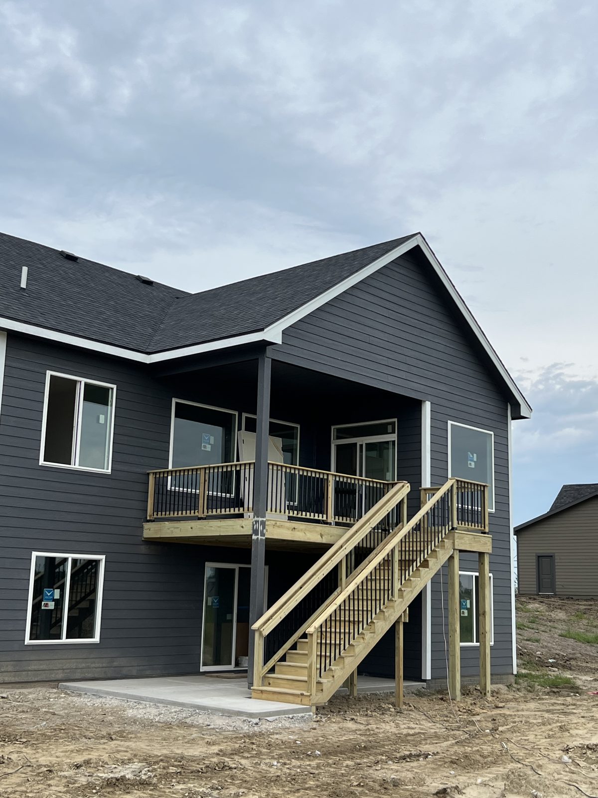 Covered second-story deck with staircase down to patio