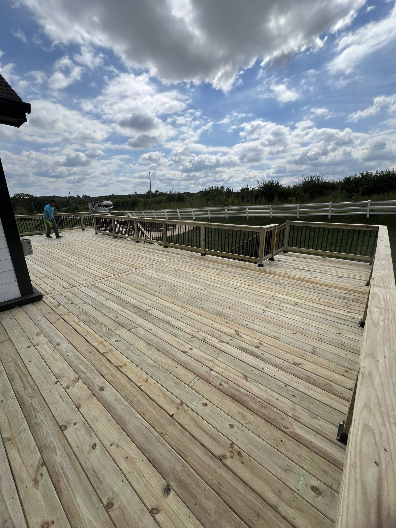 Large wood deck with black metal railing